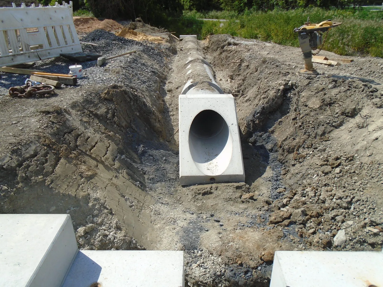 Betonrohrteil im ausgehobenen Graben