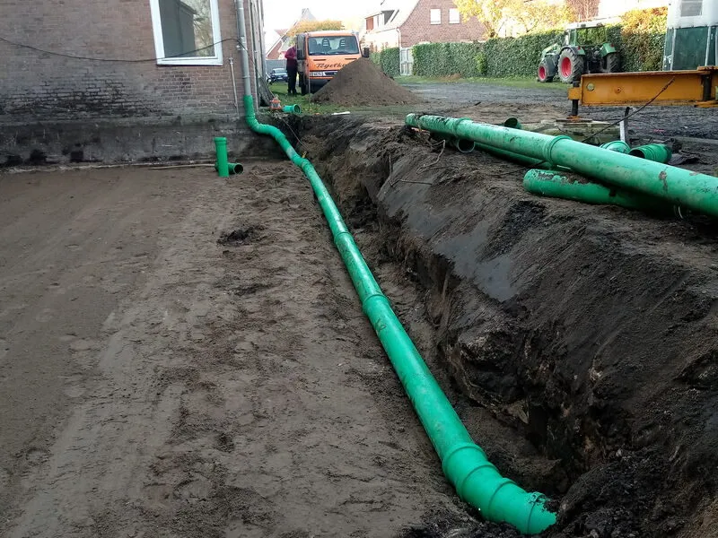 Grüne Entwässerungsleitung im Graben neben der Reithalle