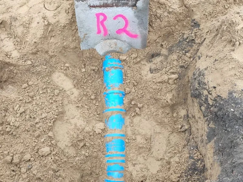 Blaue Verrohrung mit Markierung im Graben