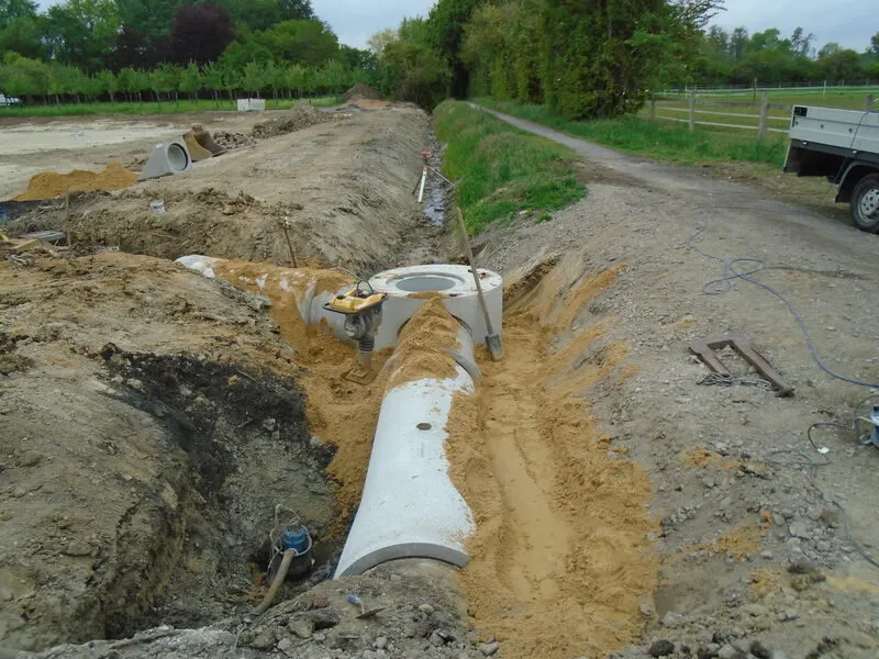 Betonrohrleitung im Graben neben einem Feldweg