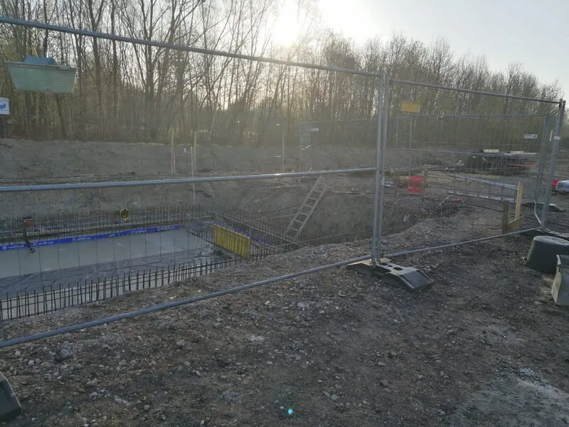 Baufeld des Regenklärbeckens hinter dem Bauzaun