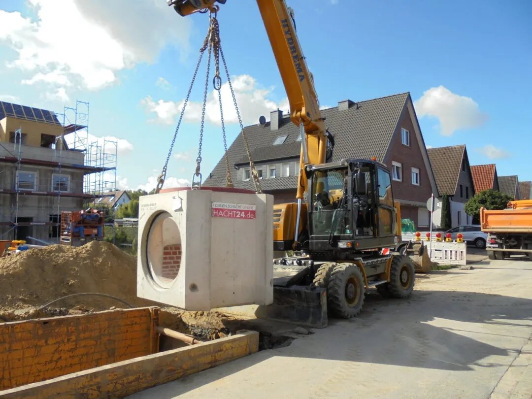 Mobilbagger hebt ein Betonbauteil in der Stifterstraße