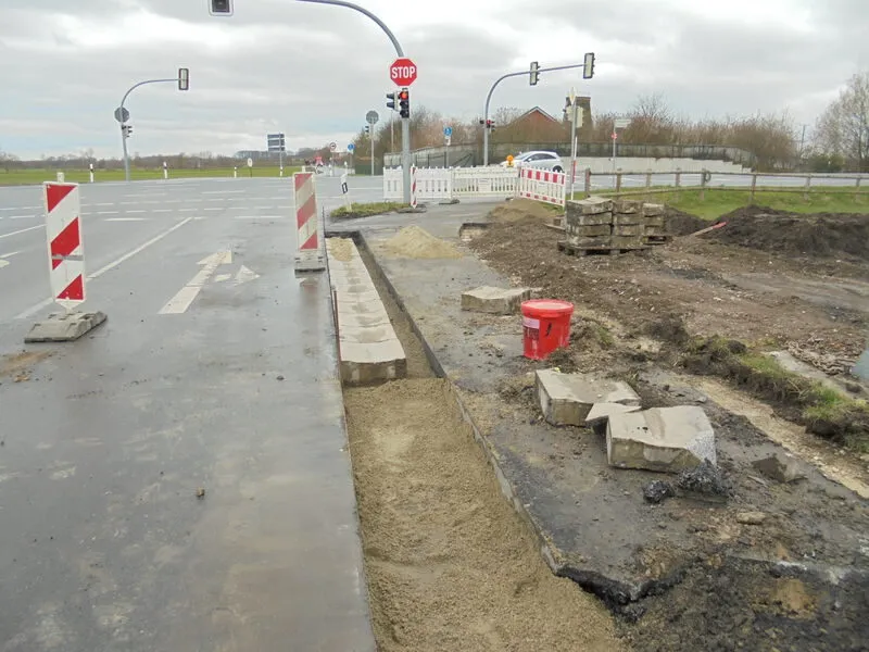 Neue Radwegtrasse an der Ampelkreuzung mit Bordsteinen