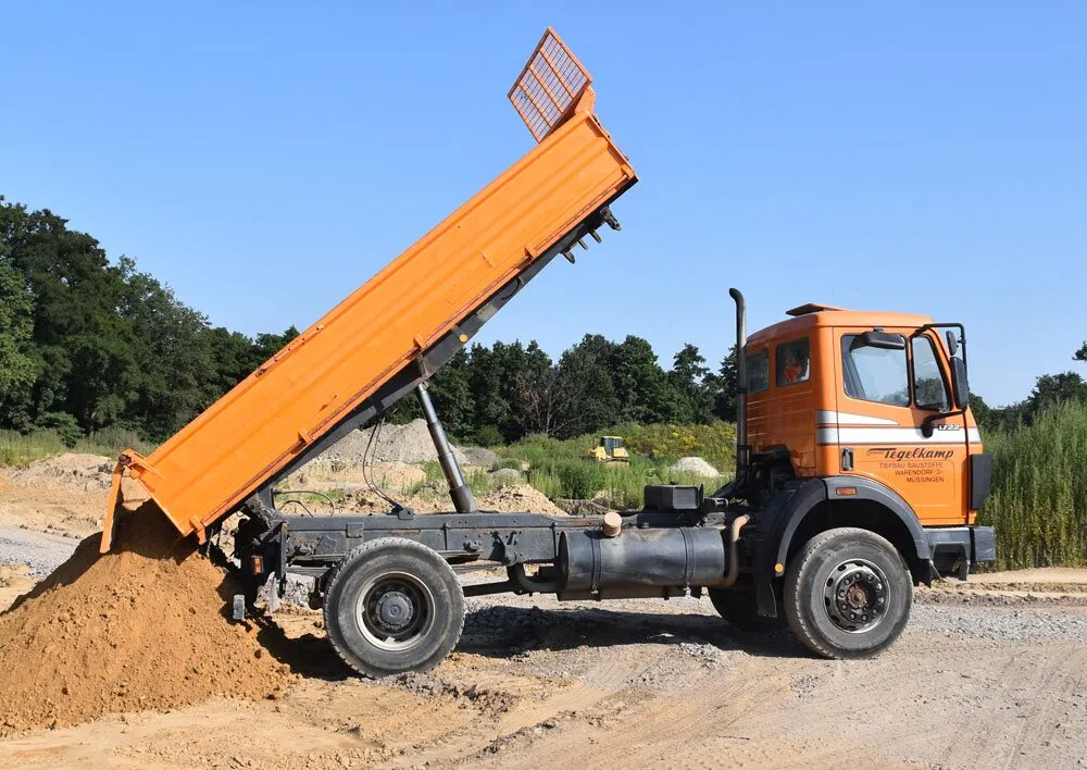 Tegelkamp-Kipplaster kippt Sand auf einer Baustelle ab